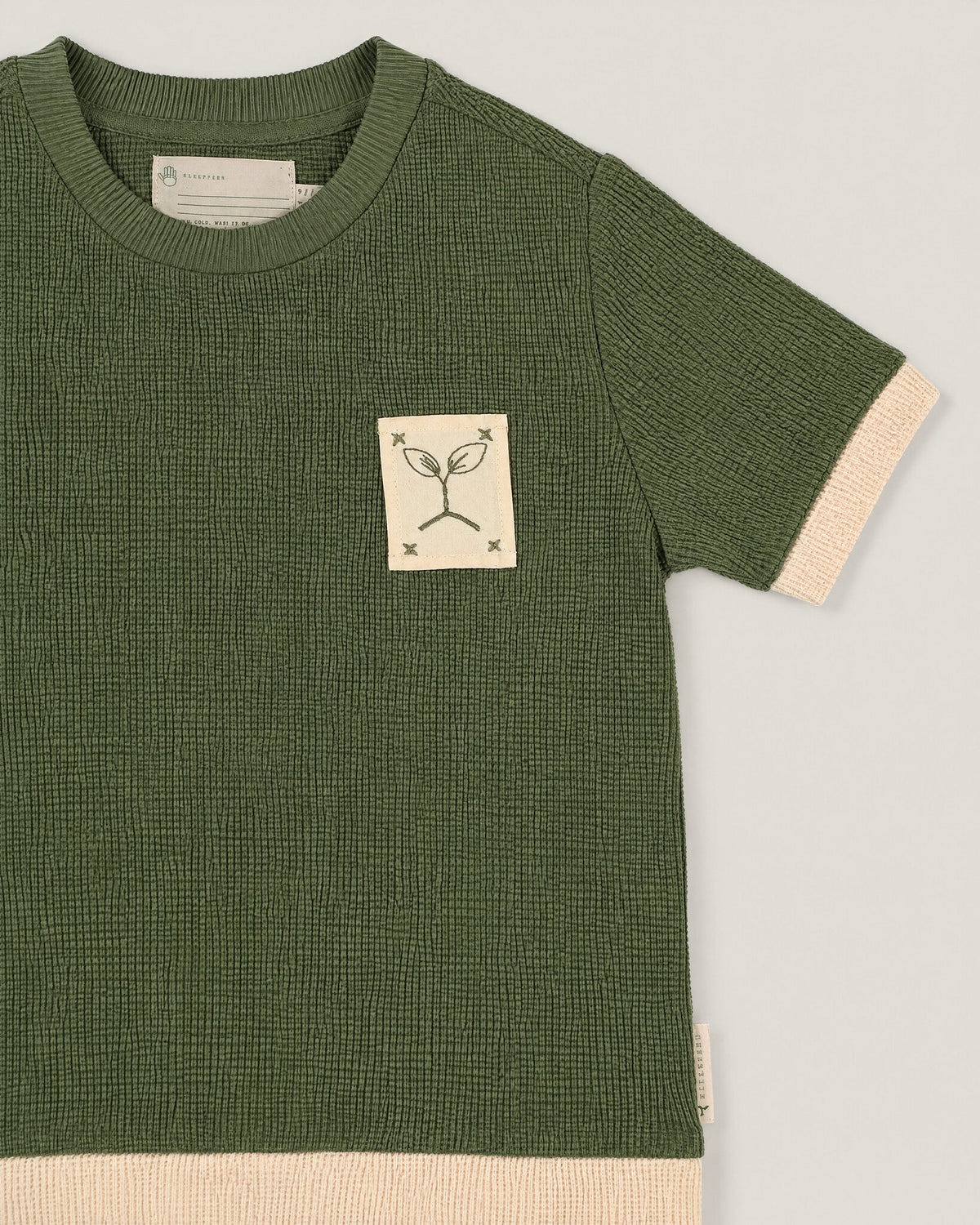 The Block Tee in Moss — waffle knit and name tape detail