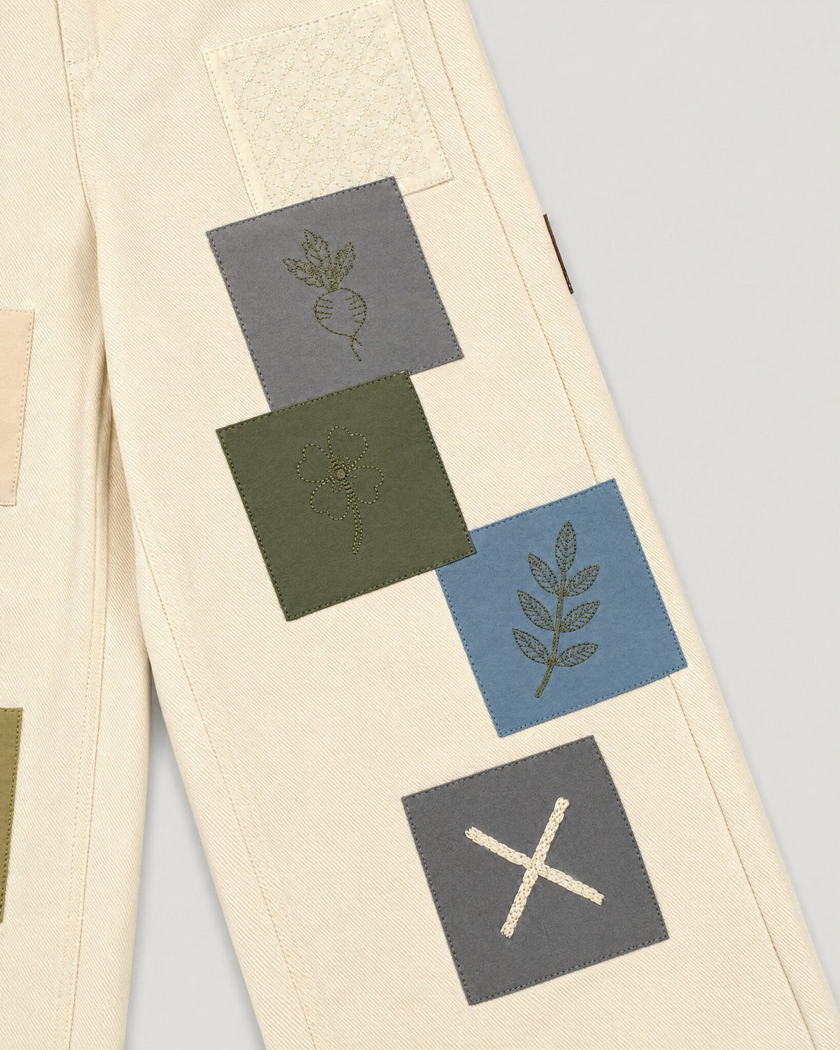 The Sampler Jeans in Ecru — patch placement along the leg