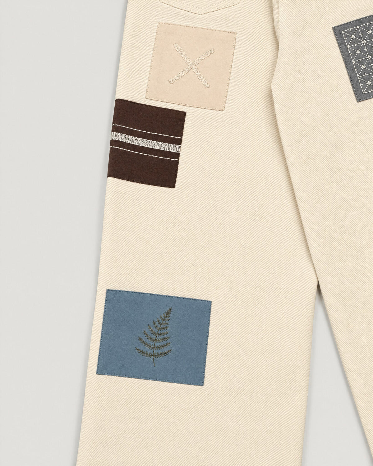 The Sampler Jeans in Ecru — patch and stitch detail